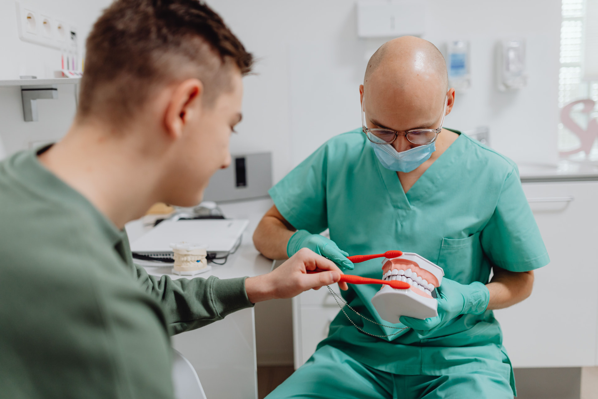A dental professional walking a colleague through a patient education model