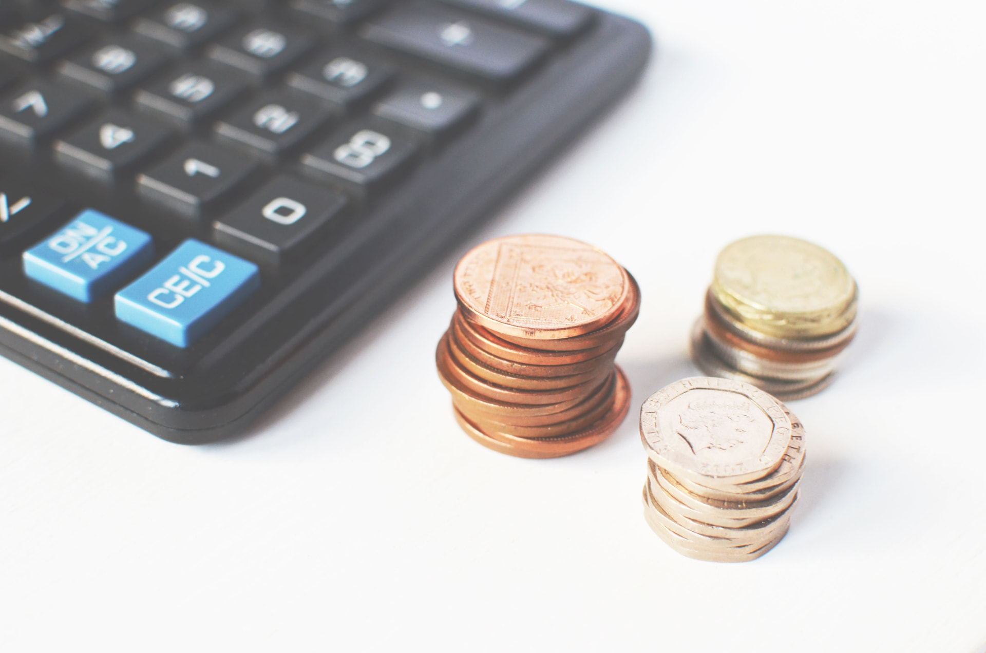 Calculator and coins used to estimate a recruiting placement fee