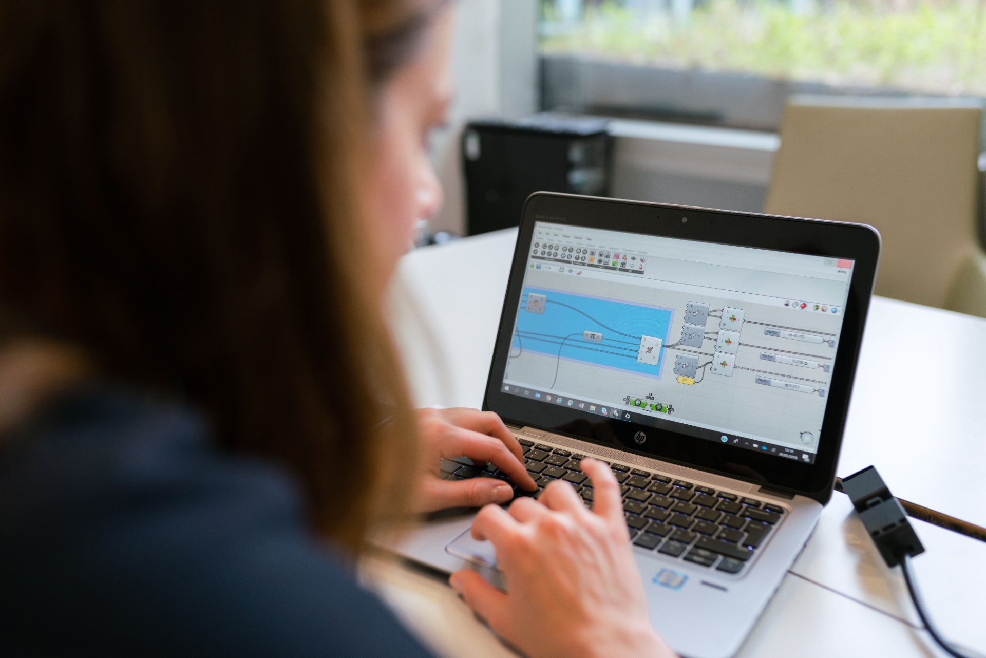 A professional reviewing candidate data on a laptop in a modern office